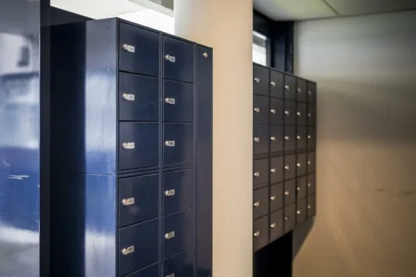 Donkerblauwe postvakkenwand in een modern gebouw aan de Markerkant.